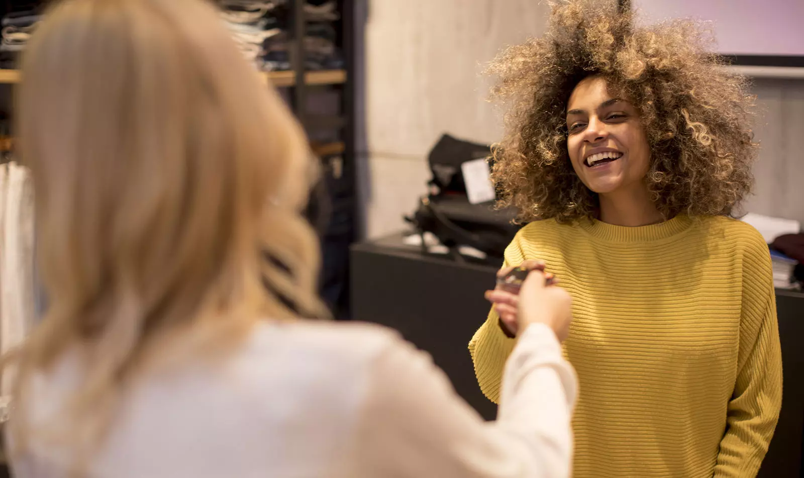 Klant en verkoopmedewerker lachen naar elkaar.